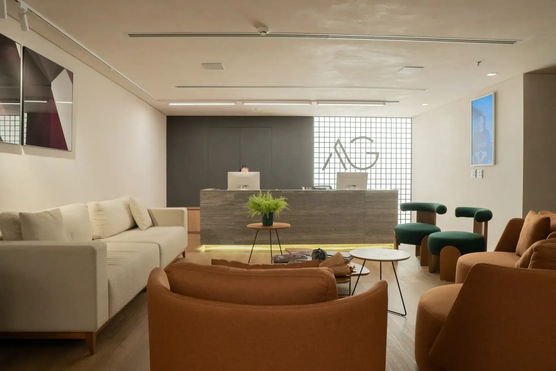 Recepção do Instituto AG, com sofás, poltronas e balcão de atendimento
